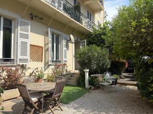 a table and chairs in front of a house at Nice Garden Hotel in Nice