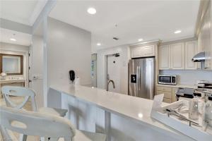 a white kitchen with a counter and a refrigerator at Bellasera Resort in Naples