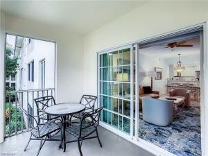 a balcony with a table and chairs and a living room at Bellasera Resort in Naples