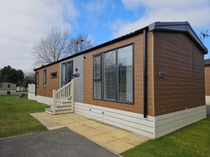 uma pequena casa com exterior marrom e branco em JJs Lodge Ebor em Allerthorpe