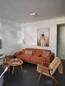 a living room with a couch and a table at Het Koetshuis, op 50m van zee, voor 5 personen, centrum Westende BAD, alle comfort in Middelkerke
