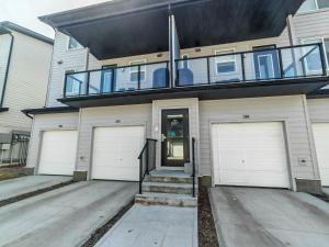 a house with two garage doors and a balcony at Sunlit Haven in Calgary