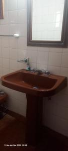 a bathroom with a brown sink and a window at VICTORIA 2 BED AND BREAKFAST A 3KM DE AEROPUERTO EZEIZa in Ezeiza