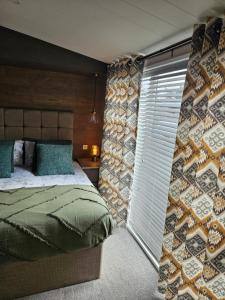um quarto com uma cama e uma parede com uma janela em JJs Lodge Ebor em Allerthorpe