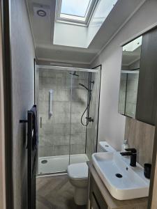 um banheiro com chuveiro, vaso sanitário e pia em JJs Lodge Ebor em Allerthorpe