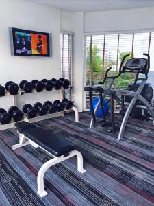a fitness room with a gym with a bench and weights at NH Bangkok Asoke in Bangkok