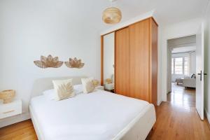 a bedroom with a white bed and a wooden door at Modern apartment - Saint-Mandé - 1BR 4P in Saint-Mandé