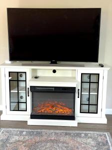 une cheminée avec une télévision à écran plat au-dessus dans l'établissement Tangerine Cottage, à Middletown