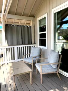- deux chaises et une table basse sur une terrasse couverte dans l'établissement Tangerine Cottage, à Middletown