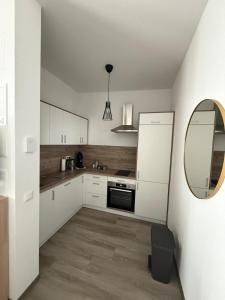 a kitchen with white cabinets and a mirror at Appartement's in Mayen in Mayen