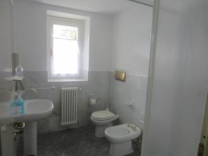 a white bathroom with a toilet and a sink at Villa Eli in Lierna