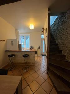 a room with a staircase and two bar stools at Le gîte nivernais in Varzy +12 photos