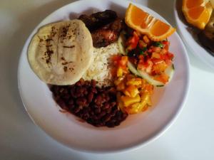 a plate of food with beans rice and orange slices at Somos Zapatón Catarata EL REY in Zapatón