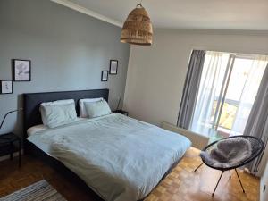 a bedroom with a bed and a chair and a window at Hasselita in Hasselt