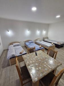 a room with three beds and a table and chairs at Konak Kod Gorana 1 in Subotica