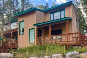 een huis met een omlopend terras met bomen bij Wapiti Point - Main House in Grand Lake