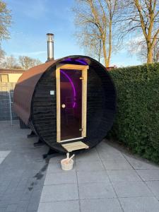 a black iguana shaped house with a door on a sidewalk at Wellness chalet Putten Hottub & Sauna in het bos in Putten