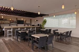 un ristorante con tavoli, sedie e un bar di Hotel Gala a Puebla