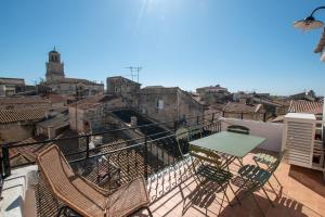 a balcony with a table and chairs on a building at Donjon - Clim - Terrasse - Premium in Arles
