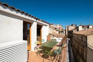 a balcony with a table and chairs on a roof at Donjon - Clim - Terrasse - Premium in Arles
