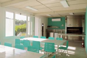 a dining room with a table and blue chairs at IQU Apart in Las Gaviotas