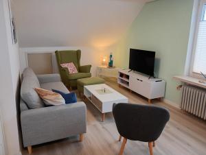 ein Wohnzimmer mit Sofa und Fernseher in der Unterkunft Ferienwohnung Nordlicht in Hage