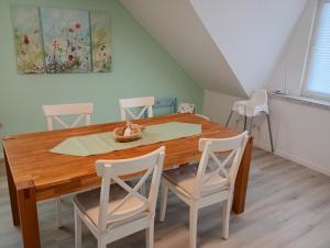 ein Esszimmer mit einem Holztisch und Stühlen in der Unterkunft Ferienwohnung Nordlicht in Hage