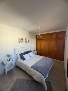 ein Schlafzimmer mit einem großen Bett und Holzschränken in der Unterkunft Casa Velalatina in La Santa