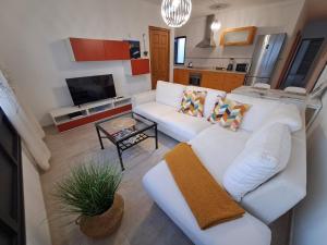 a living room with a white couch and a table at Casa Velalatina in La Santa