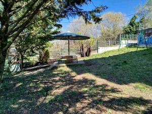 a picnic table with an umbrella in a yard at Xara' s studio in Kozani
