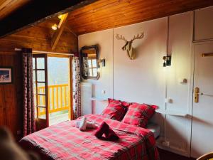une chambre avec un lit rouge avec des oreillers rouges dans l'établissement Chalet chaleureux à Ax-les-Thermes avec vue sur la montagne, à Ax-les-Thermes