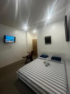 a bedroom with a bed with a teddy bear on it at Villa Talisay Kaputian - Streetside Studio in Samal