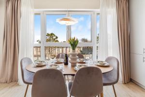 a dining room with a table and chairs and a large window at Celine in Infinity Pool & Spa Resort in Năvodari