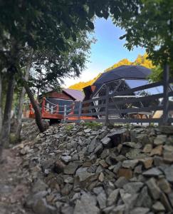 a building with a fence and a pile of rocks at Riverside Dome in Dobra