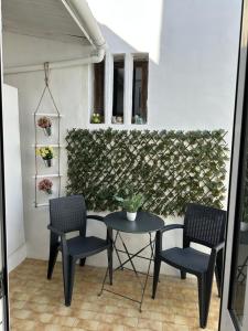a patio with a table and chairs and a wall at Casa Azul Altamira in Viana do Castelo