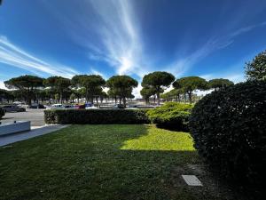 a park with bushes and trees and a blue sky at Green garden apartment in Lignano Sabbiadoro