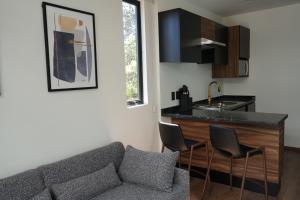 a living room with a couch and a kitchen at Container Woods in Valle de Bravo