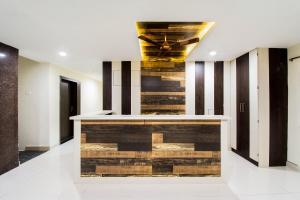 un vestíbulo con un bar con una pared de madera en Super Hotel O CJ Inn, en Vijayawada