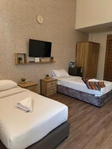 a hotel room with two beds and a flat screen tv at Gate Inn in Amman