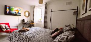 a bedroom with a bed and a tv on the wall at Asal Family House in Fife