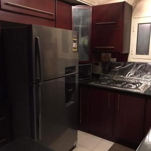 a kitchen with a stainless steel refrigerator and wooden cabinets at birds House in Jerash +16 photos