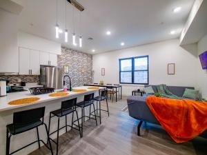 a kitchen and living room with a bar with stools at Stylish and Modern 2 - Bedroom apt minutes from NYC! in Bayonne