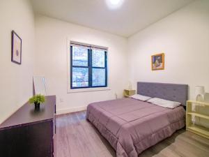 a bedroom with a bed and a desk and a window at Stylish and Modern 2 - Bedroom apt minutes from NYC! in Bayonne
