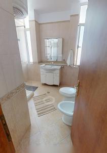 a bathroom with two toilets and a sink at Coastal Nest Apartments in Durrës +15 photos