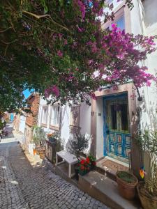 a building with a blue door on a street with flowers at Gaja Ayvalık in Ayvalık