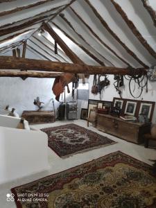 an attic room with rugs on the floor and a ceiling at Casa Capricho del Destino in Villatobas