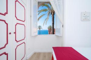 a room with a window with a view of the ocean at Sunset House Costiera Sorrentina in Vico Equense +25 photos