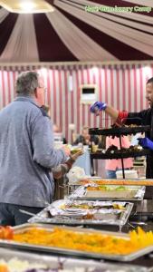 a man standing at a buffet line with food at Rum mona in Wadi Rum