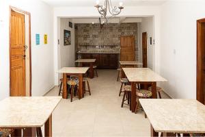 a room with tables and chairs and a kitchen at Pousada Nativos Lençois in Lençóis