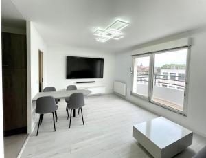 a living room with a table and chairs and a large window at Petit nid douillet in Dieppe